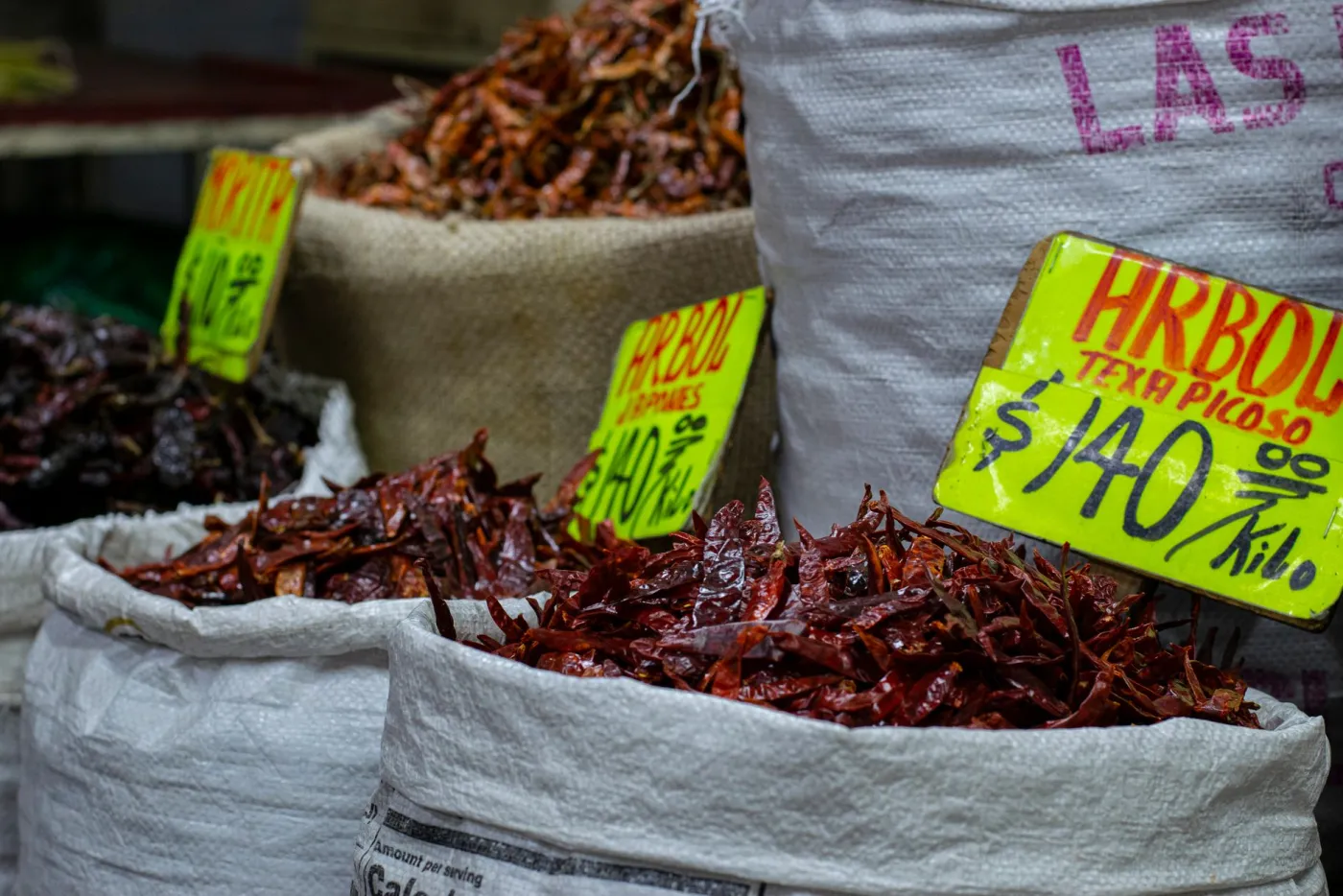 Sacks of dried chiles at a Mexican market, priced by the kilo.